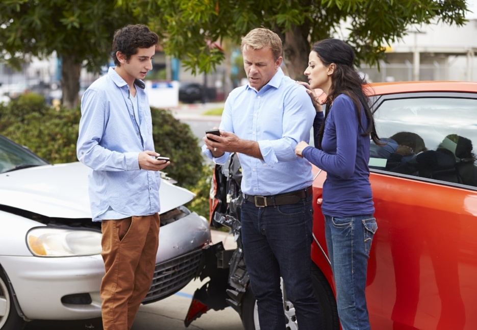 people exchanging information at the scene of a car accident